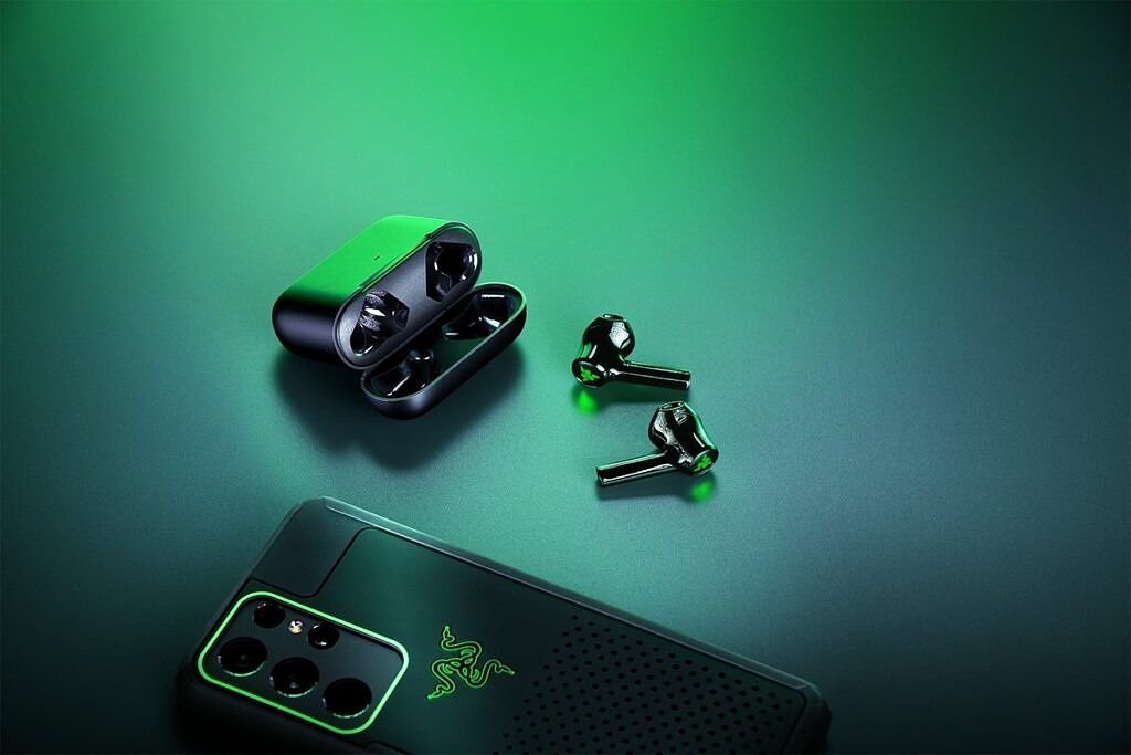 Hammerhead True Wireless X earbuds lying on their side alongside the charging case and a smartphone