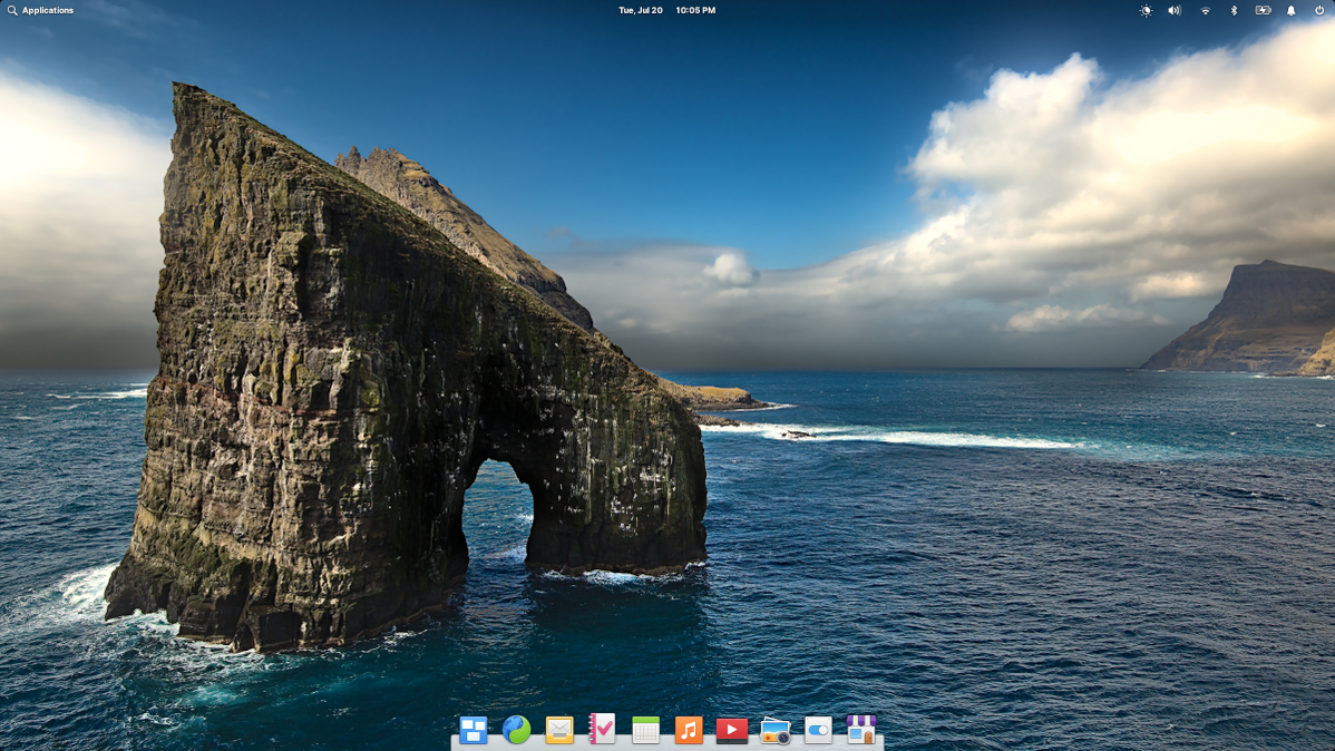 elementary OS 6 desktop with wallpaper featuring a horseshoe shaped rock in the sea.