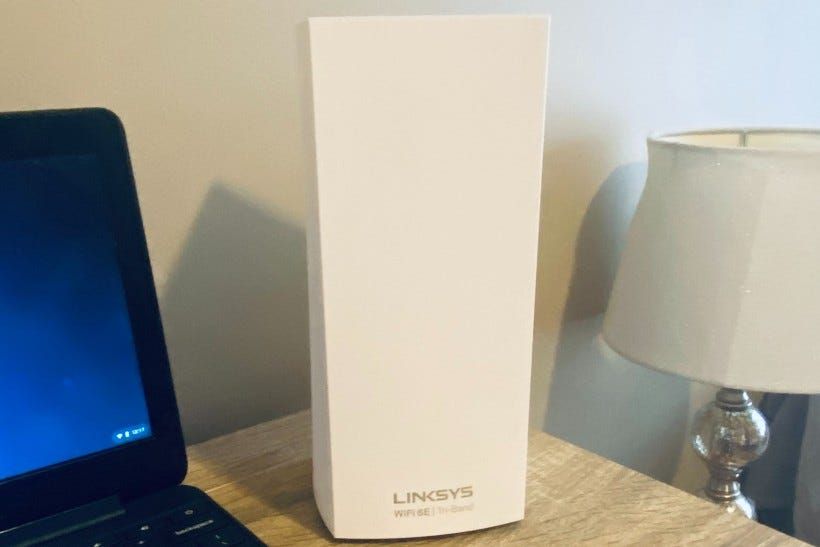 The Linksys Atlas Wifi 6E router near a laptop