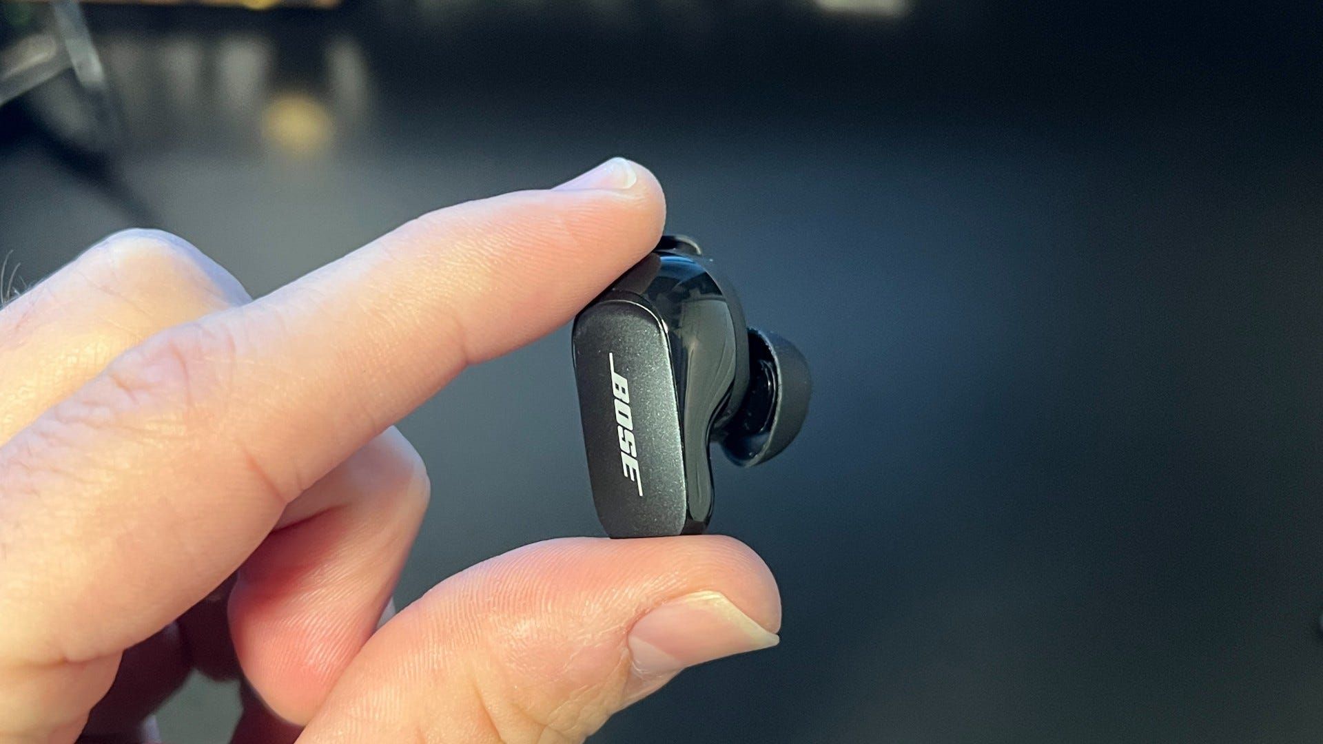 Bose Quiet Comfort 2 Earbud in between fingers with stem back showing