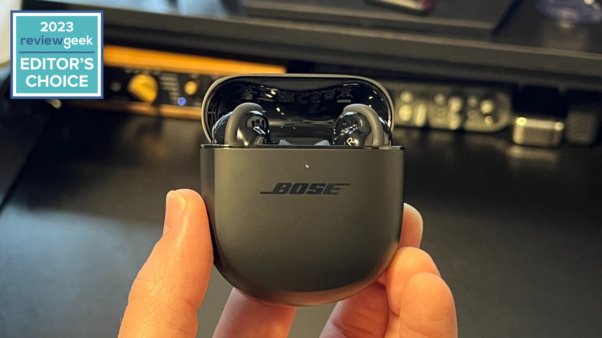 Bose QuietComfort Earbuds in open black case above black desk